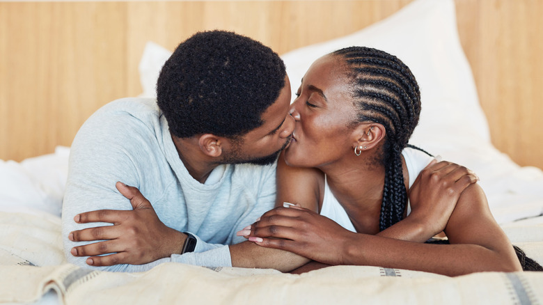 A couple kissing in bed 