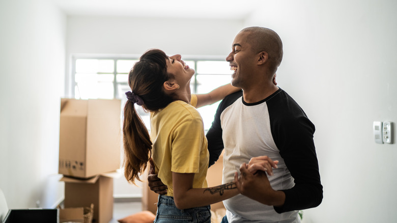 interracial couple dancing in. new house