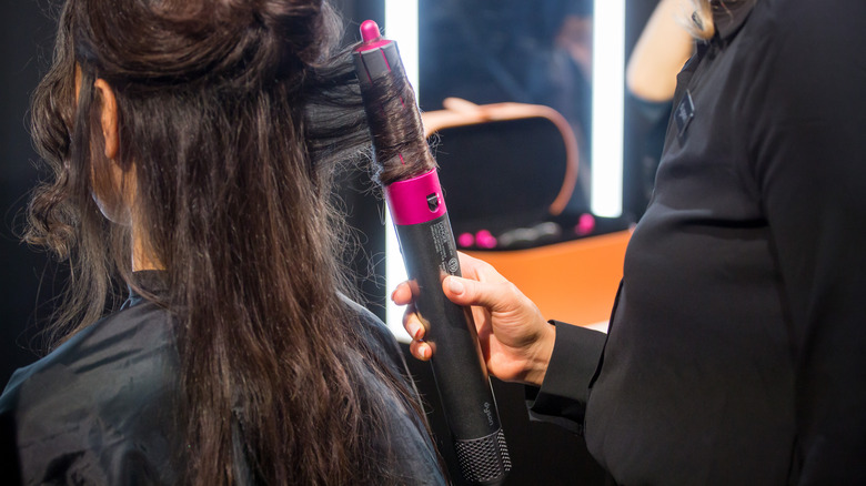 Woman using Dyson blow dryer