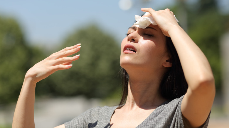 Woman wiping sweat off forehead