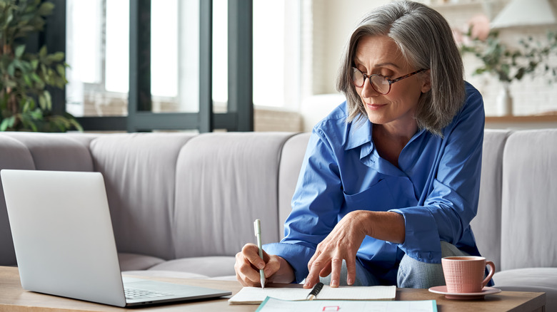 Older woman writing in notebook
