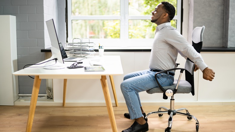 Person stretching at desk