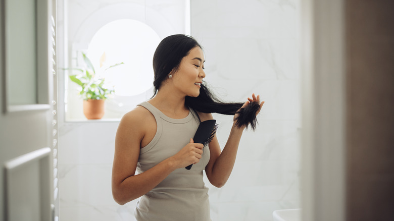 smiling woman detangling long hair