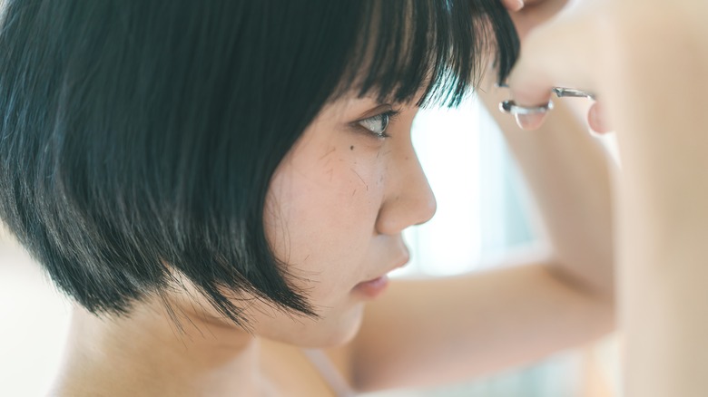 Woman trimming bangs