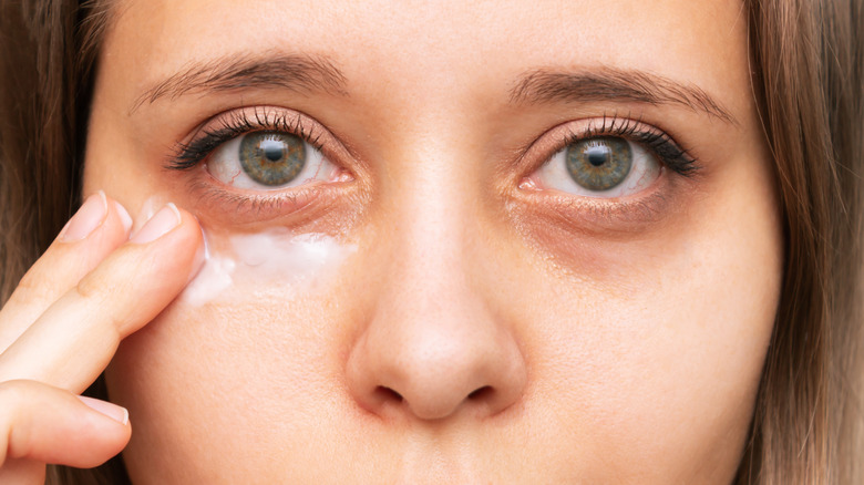 Woman applying eye cream