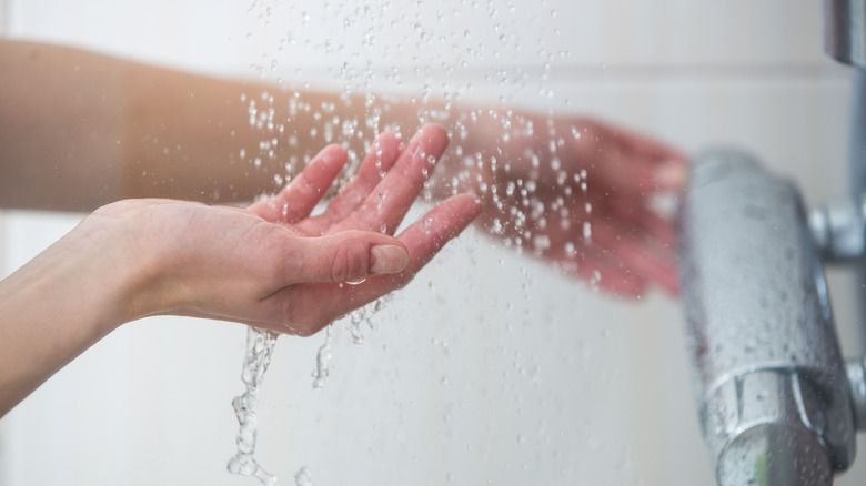 checking water temperature in shower