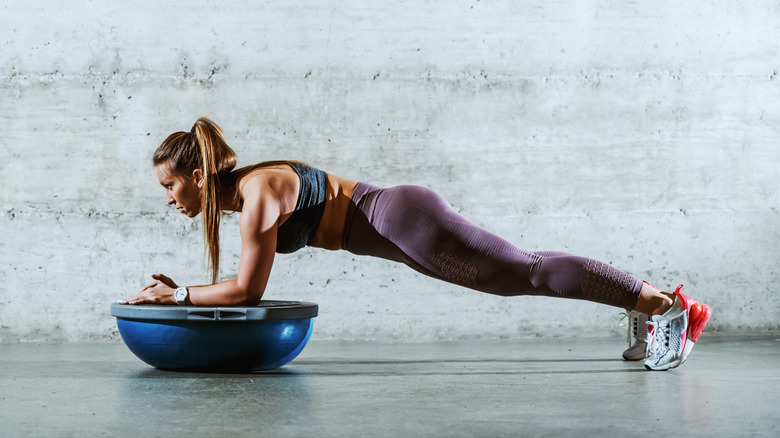 Woman planking on a Bosu ball 