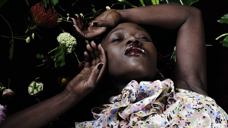 Demure woman resting on plants