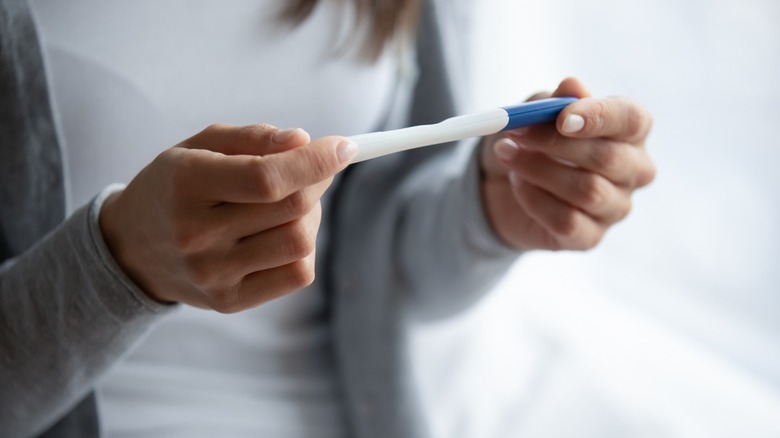 Woman holding pregnancy test