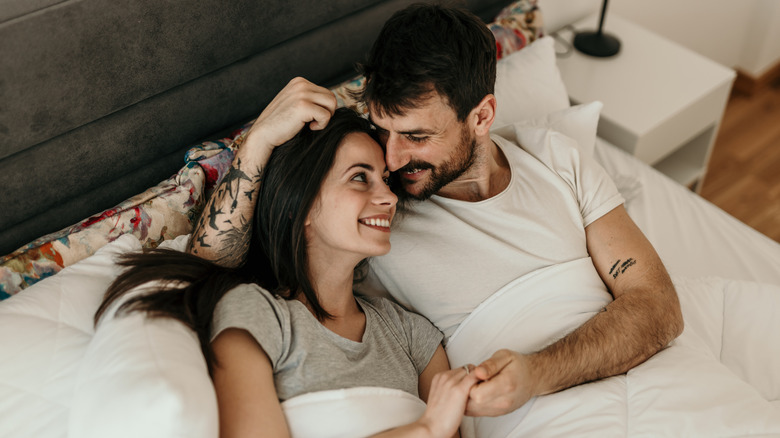 Couple cuddling on bed