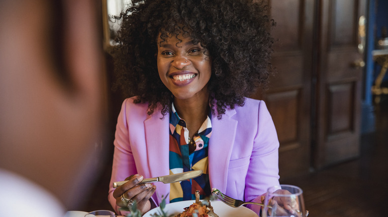 Smiling woman eating in restaurant