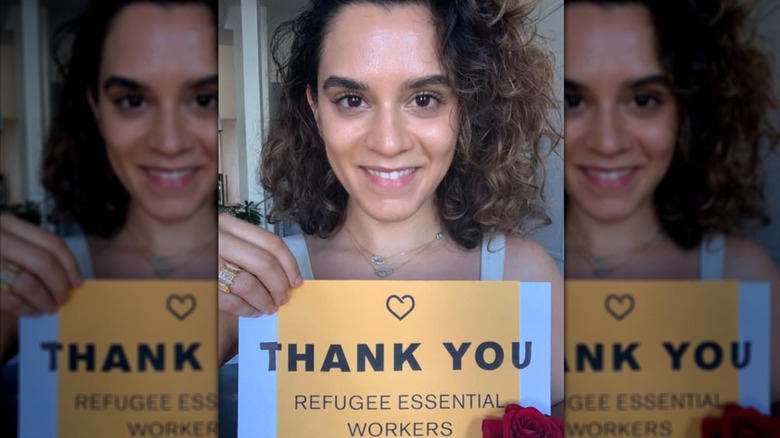 Sepideh Moafi holding up a sign that says "Thank you refugee essential workers"