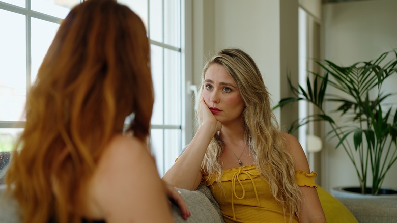 two women talking on couch
