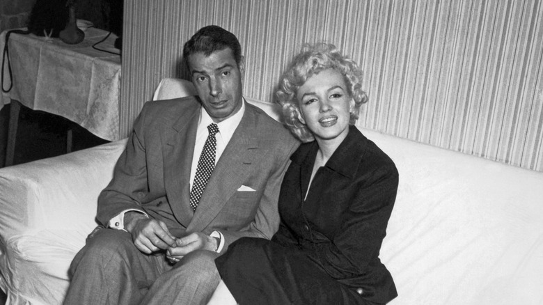 Joe DiMaggio and Marilyn Monroe sitting on a sofa together