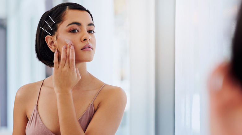 Woman moisturizing face