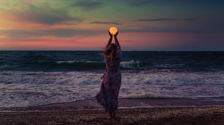 woman holds moon in hands