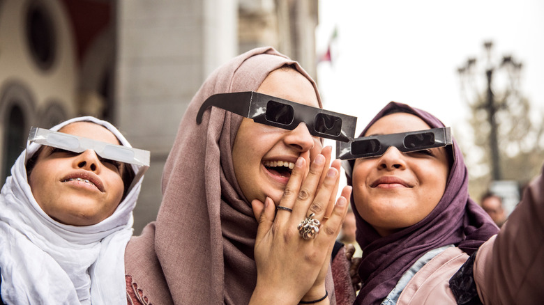 women in eclipse glasses