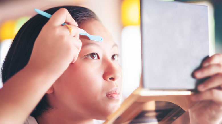 Woman shaving face