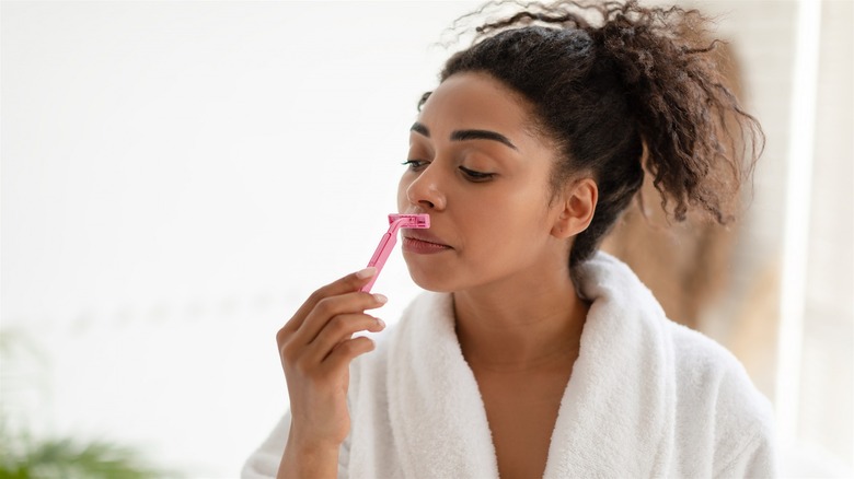 Woman shaving her face