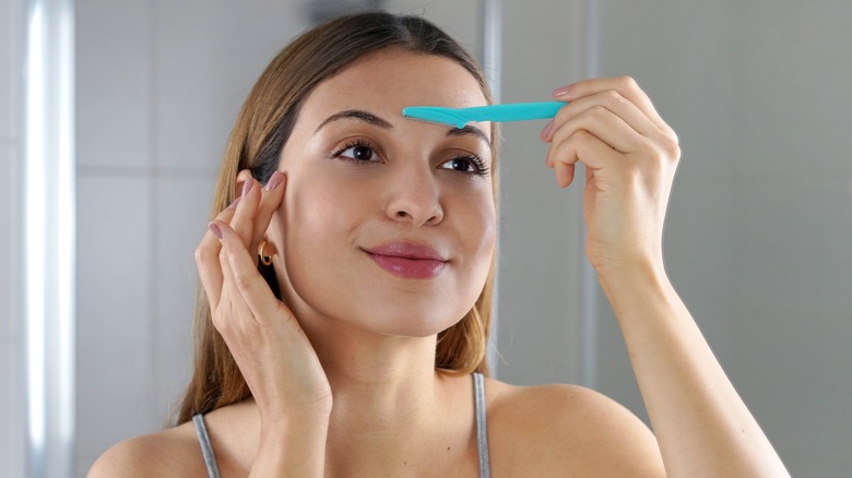 Woman shaving her face
