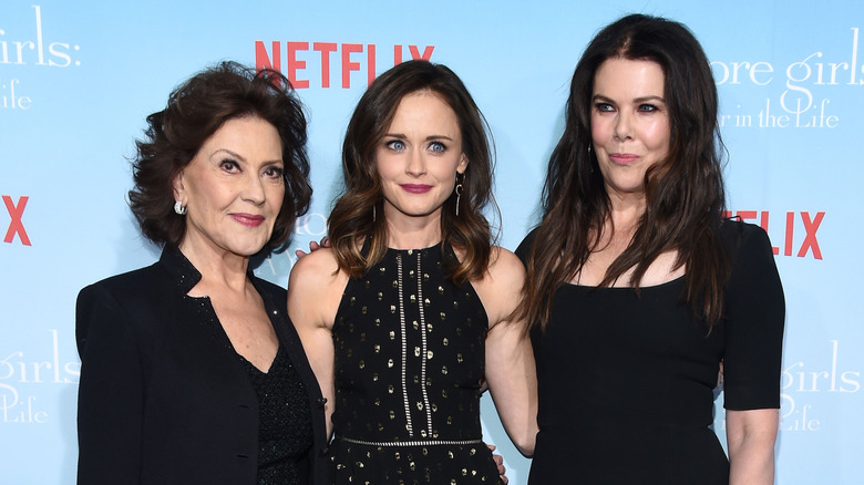 Lauren Graham, Alexis Bledel, and Kelly Bishop all wearing black and standing together on the red carpet