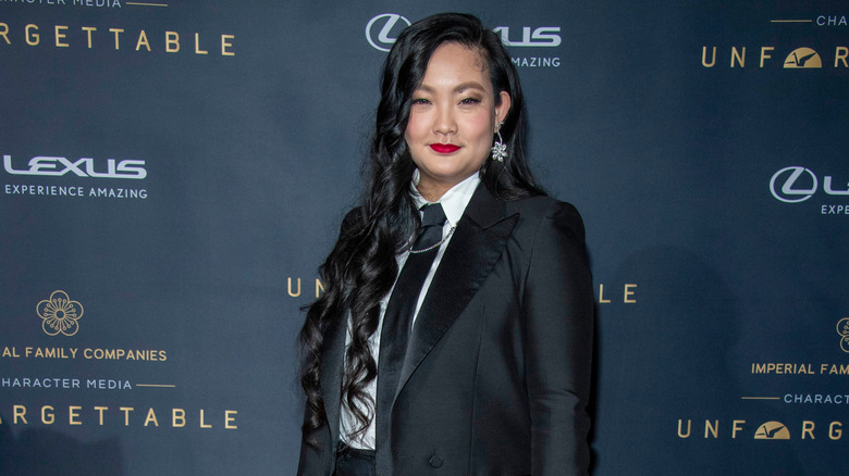 Amanda Nguyen at an event wearing a black suit and red lipstick with her hair down