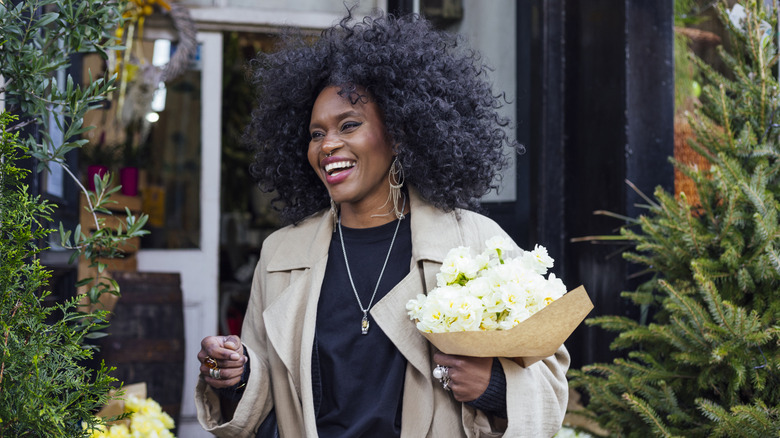 Woman holding flowers for herself and smiling