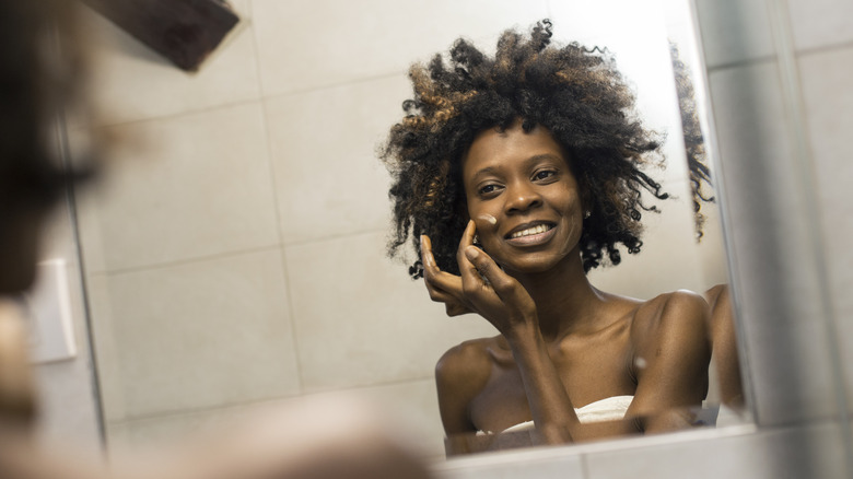 Woman applying moisturizer