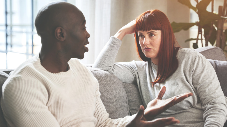man and woman on couch talking