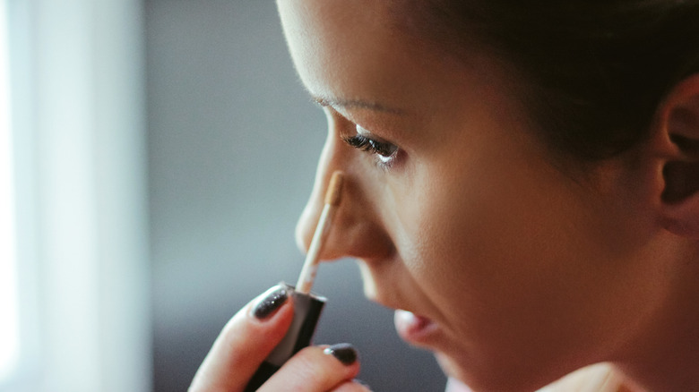 Woman applying concealer