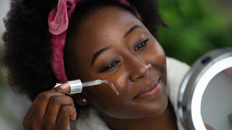 Woman applying face serum