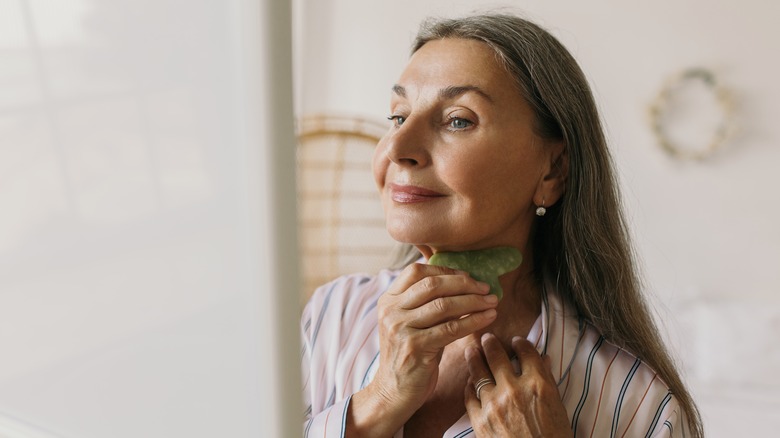 Woman uses gua sha tool 