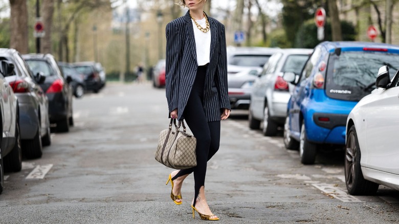 model in street with leggings and heels