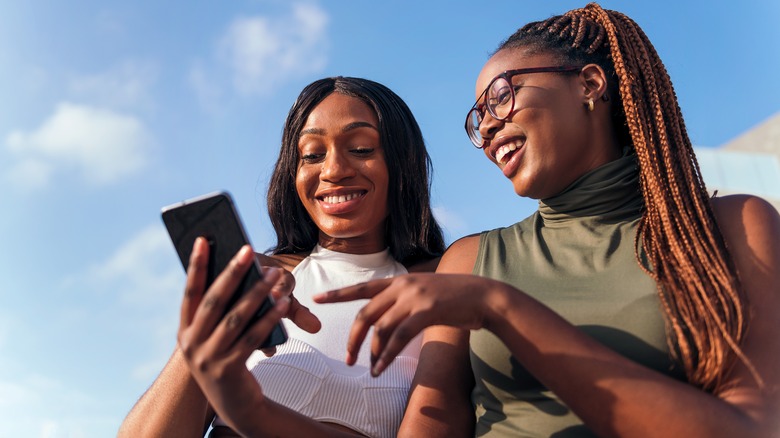 Woman showing friend app profile