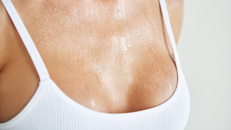 A woman in a sports bra, sweating 