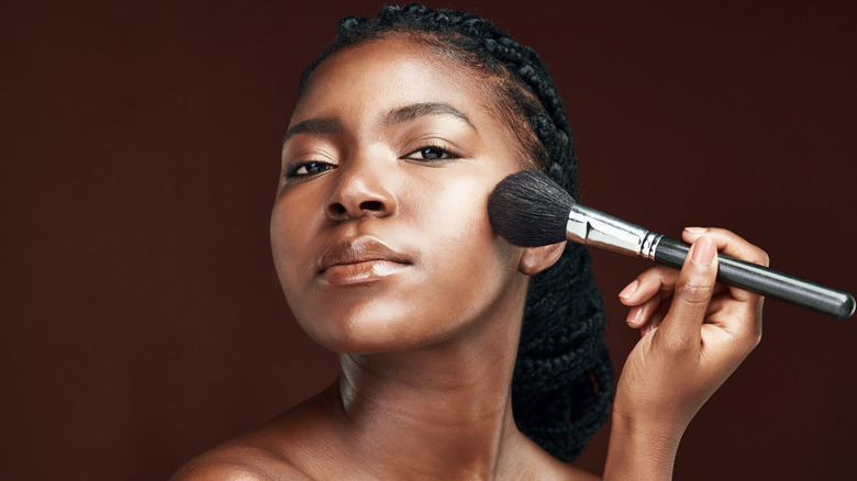 Woman applying blush