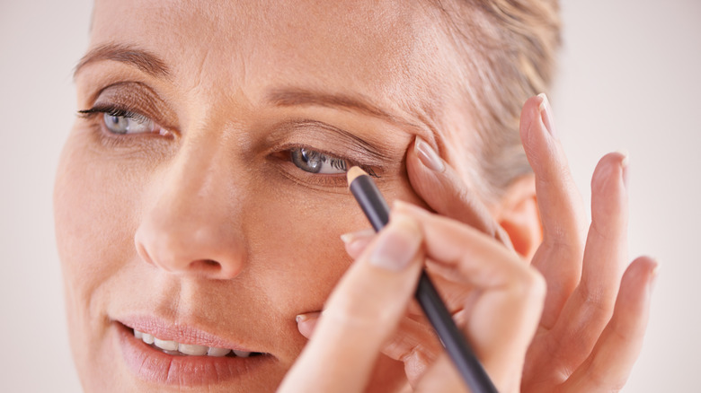 Older woman preparing to apply eyeliner