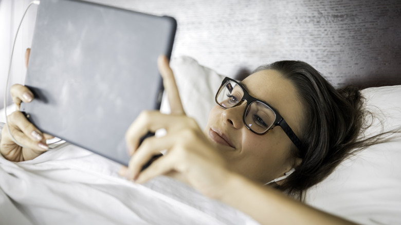 Woman using tablet in bed