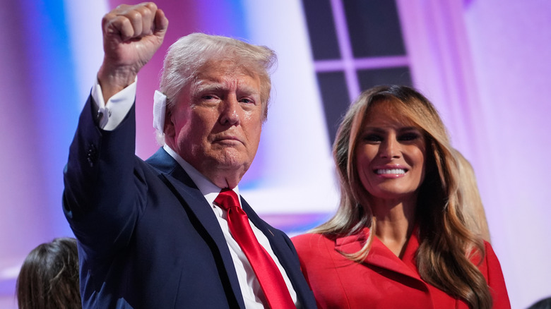 Donald Trump in a blue suit and Melania Trump in a red blazer at an event
