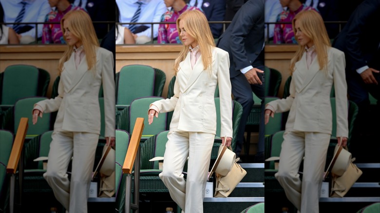 Nicole Kidman descending the steps in the Wimbledon stands and wearing a slim-fit white suit