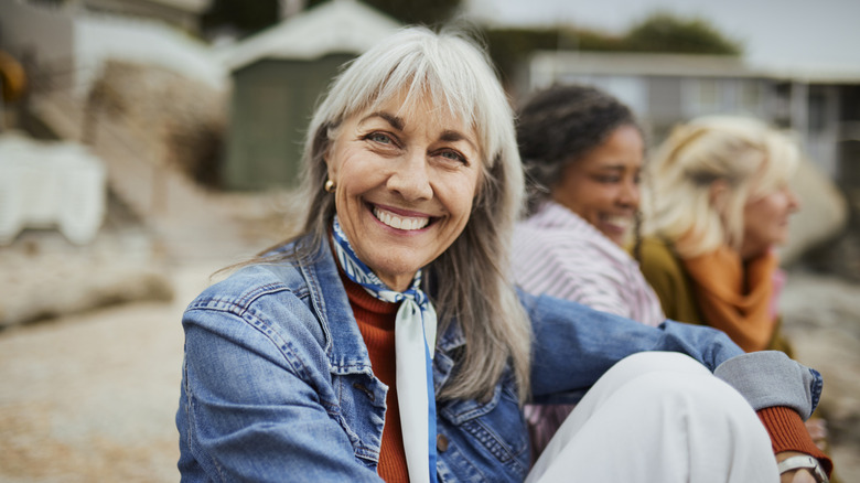 A smiling mature woman sitting on a beach