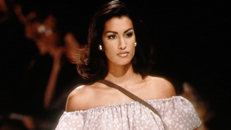 Yasmeen Ghauri walking the runway in an off-the-shoulder dress