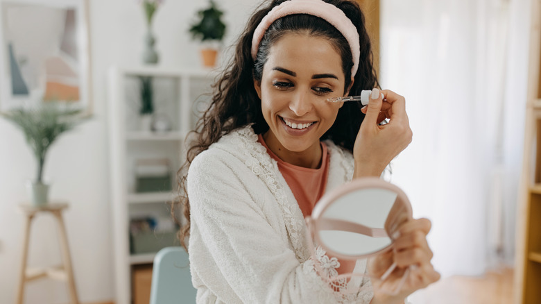 A woman applying face serum