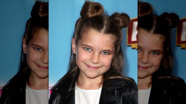 Raegan Revord smiling while wearing a half-updo with space buns in 2018