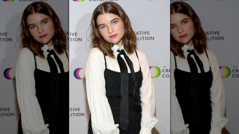 Raegan Revord posing at a 2023 event with a middle-parted, collarbone-length haircut