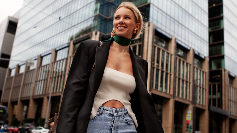 A woman wearing a blazer and jeans