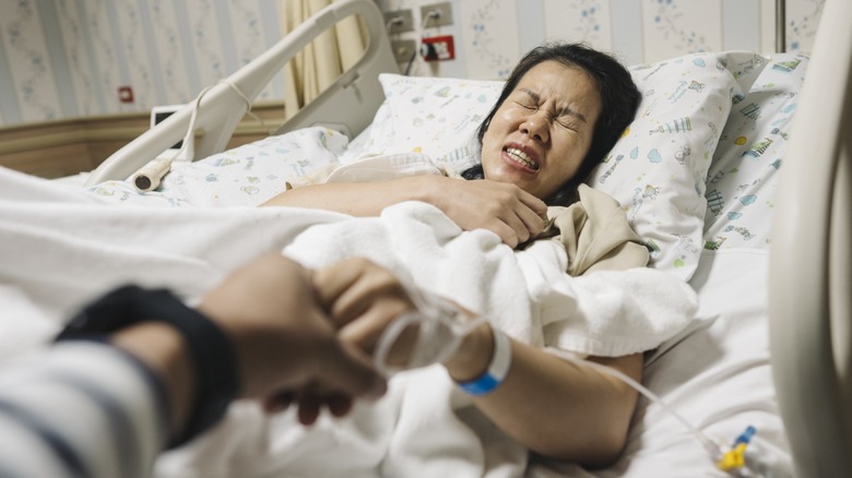A woman giving birth in a hospital bed