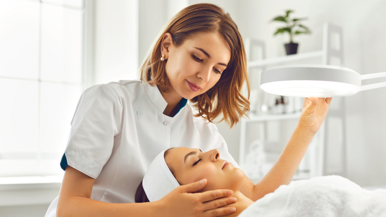 esthetician giving woman a facial
