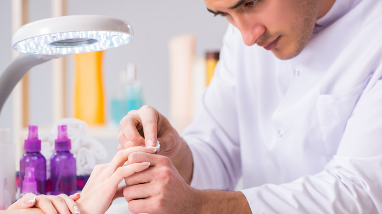 Man cleaning client nails