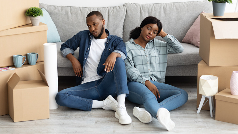 Couple sad around packed boxes